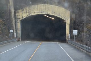 Whittier Access Road east crosses Portage Creek and enters Portage Lake Tunnel south of Begich Peak.