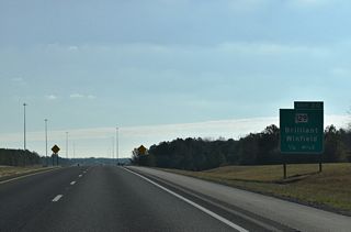 One half mile west of the diamond interchange (Exit 30) with SR 129. SR 129 travels 41.19 miles overall between U.S. 43 near Lawrence Mill and Haleyville.