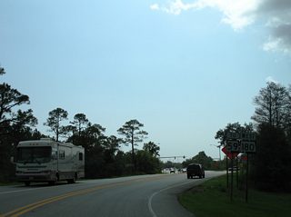 Following Fort Morgan Road away from State Park Road toward SR 59. The succeeding traffic light on SR 180 west is at a Wal-mart entrance.