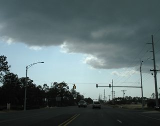 Westbound SR 180 (Canal Road) at the northbound beginning of the Foley Beach Express. The toll road initially carries just two lanes northward across the Intracoastal Waterway. Drivers turning north here may also access Wharf Lane east before committing to the toll bridge.