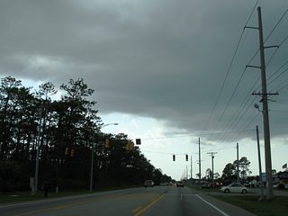 Canal Road gains a north side frontage road (Commercial Way) between Oak Street and Spinnaker Way. Strip mall type development lines the service road before and after the signalized intersection with Gulf Bay Road north.