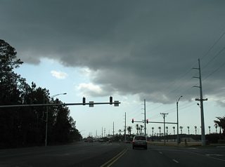 SR 180 (Canal Road) widens to four lanes on the south side of The Wharf. A signalized intersection joins Main Street, the main entry point into the adjacent development, with Canal Road in this scene.