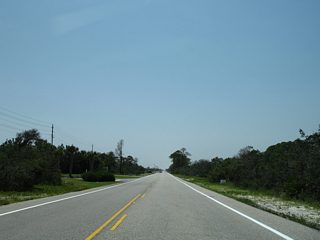 A scene along SR 180 (Dixie Graves Parkway) westbound between Gulf Shores and Fort Morgan. For the most part the highway offers a 55 MPH speed limit as it travels through forest, marshland, and a hodgepodge of beach home communities.