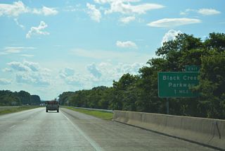 One mile east of the diamond interchange (Exit 2) with Black Creek Parkway.
