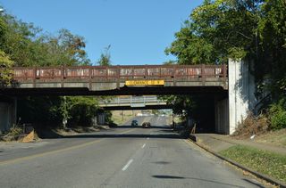 Back to back overpasses span 5th Avenue N east of 31st Street North. The first is an abandoned railroad bridge; the second carries a CSX Railroad line.