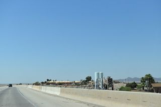Two steel through truss bridges are visible to the north of Interstate 8 across the Colorado River. The bridge along Business Loop I-8 between Yuma and Winterhaven can be seen to the south of the freeway.