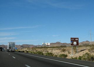 The pre-1952 alignment of Historic U.S. 66 angles southwest along Oatman Highway toward the Black Mountains. Historic U.S. 66 continues northeast to the BNSF Railroad siding of McConnico.