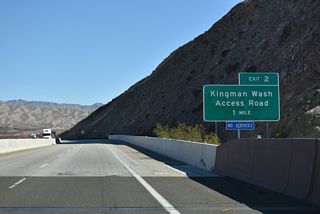 U.S. 93 curves southeast one mile from the Mike O' Callaghan-Pat Tillman Memorial Bridge to Exit 2 for Kingman Wash Access Road.