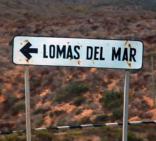 old white guide sign on La Bufadora access road
