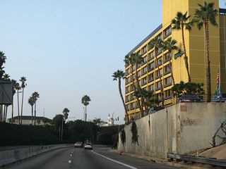 SR 1 passes between a hotel and Tongya Park ahead of the McClure Tunnel, which carries traffic under the Palisades.