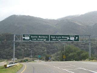 Southbound California 1 approaches U.S. 101 near Las Cruces as it descends from the mountains between Lompoc and Gaviota. At this point, California 1 is traveling due east toward its rendezvous with U.S. 101. There is a hot spring located at this U.S. 101 & California 1 interchange at Las Cruces, but it has not yet been field tested. As to the overhead signs, these are very old, 1960s-era signs, but the "to" overlay was likely added at some point thereafter.