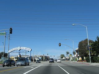With several high-tension power lines passing overhead, northbound California 1 meets Catalina Avenue. This road travels southwest and then south to parallel the coast, offering more beach views than those found on California 1 itself. A sign heralding the Redondo Beach Pier is located at this intersection, even though the pier itself is located several blocks south of here. The sign is marked here mostly for southbound travelers using Catalina Avenue to travel to the pier.
