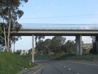 Two lanes link Interstate 5 north with California 1 (Pacific Coast Highway) north. High above is Via California, a local street in Dana Point. Prior to 1964, the segment of California 1 between Interstate 5 in Dana Point-San Juan Capistrano and U.S. 101 in Oxnard was designated as Alternate U.S. 101. This designation was eliminated in favor of a newly extended California 1 designation, since California 1 is the coastal route for significant distances in Central and Northern California. No signage remains for Alternate U.S. 101, and some sections of California 1 are maintained locally by the cities through which it passes.