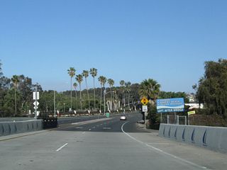 The city of Dana Point placed this advance guide sign, advising traffic to use Dana Point Harbor Drive west to Doheny State Beach, Dana Point Harbor, and Ocean Institute. Watch for cross-traffic ahead.