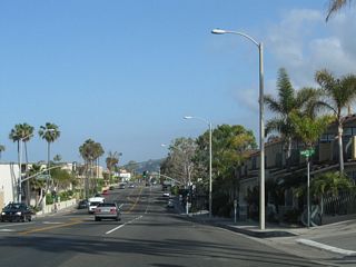 A porcelain enamel street sign for Agate Street precedes the signalized intersection with Bluebird Canyon Drive.
