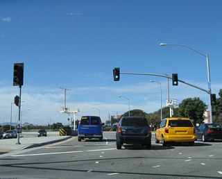 Northbound California 1 has a traffic signal at the intersection with southbound traffic for Sepulveda Boulevard. Lincoln Boulevard begins ahead.