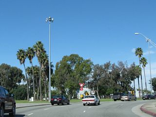 First intersecting Outer Traffic Circle, northbound California 1 (Pacific Coast Highway) enters Los Alamitos Traffic Circle. Several high mast lights are located within the turf traffic circle.