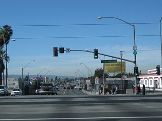 Westbound California 1 meets Long Beach Boulevard at this traffic signal. The Metro Blue Line uses the median of Long Beach Boulevard for its light rail service that connects Union Station in downtown Los Angeles with a terminal in downtown Long Beach.
