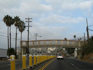Another pedestrian bridge crosses over the busy Pacific Coast Highway. A signalized intersection with Porto Marina Way follows.