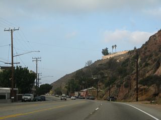 Fragile sandstone cliffs line the northern edge of California 1 (Pacific Coast Highway) westward through Malibu. The bulk of the homes in this view burned during the Palisades Fire.