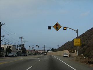 Las Flores Canyon Road and Ramble Pacifico Street south tie into California 1 (Pacific Coast Highway) at succeeding signalized intersections and Las Flores. Both streets lead north into the hills, offering access to residential areas and evetually linking to Stunt Road and Mulholland Highway. Between the two intersections is a 1931 bridge with old style railing.