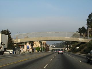 The California Incline descends to a signalized intersection with California 1 between pedestrian bridges.
