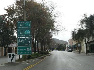 After crossing the Santa Ynez River and traveling south through downtown Lompoc, California 1 approaches California 246 (Ocean Avenue) after the intersection with Walnut Avenue. This sign provides the mileage to Surf via California 246 west and Buellton via California 246 east. California 1 turns left along with California 246 for a brief overlap through southern Lompoc.