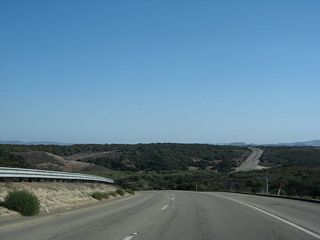 Coastal scrub and rolling hills dominate the view of unspoiled areas within the Space Force Base.