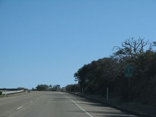 A California 1 south reassurance shield is posted after the Santa Lucia Canyon Road intersection.