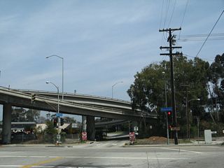 Northbound Allesandro Street meets Riverside Drive in Los Angeles. The Interstate 5 (Golden State Freeway) and California 2 (Glendale Freeway) interchange is visible ahead. Not visible behind the freeway is the Los Angeles River.