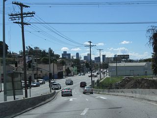 Westbound (southbound) California 2 curves onto Glendale Boulevard south. The skyscrapers of downtown Los Angeles come into view in the distance. Plans originally called for the California 2 freeway to continue southwest through Echo Park to meet U.S. 101, but this connection looks unlikely to be constructed. And the once-proposed, very controversial Beverly Hills Freeway that would have continued southwest toward Santa Monica is also dead. For now (and probably forever), Glendale Boulevard serves as the southern terminus of the California 2 freeway (excepting the short segment of shared alignment with U.S. 101). The state route, however, continues onto Glendale Boulevard south.
