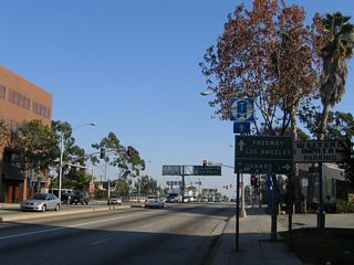 Southbound Lincoln Boulevard approaches two intersections with Olympic Boulevard. The first is one-way westbound, while the second is one-way eastbound. Here, Olympic basically serves as a frontage road on either side of Interstate 10, facilitating access to the eastbound freeway or northbound Pacific Coast Highway. A smaller roadside sign here advises that traffic for Oxnard (implied to be California 1 (Pacific Coast Highway) north) should turn right on Olympic Boulevard, while traffic bound for Interstate 10 (Santa Monica Freeway) east to Los Angeles should continue straight over the freeway and prepare to turn left at the second Olympic Boulevard intersection.