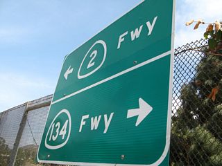 In Glendale, eastbound Wilson Terrace meets Harvey Drive near an In-N-Out Burger Restaurant. This sign points the way to California 2 and California 134, since this intersection is just northwest of the 2-134 interchange. Directly behind and underneath this intersection is a transition ramp from California 2 south to California 134 west.