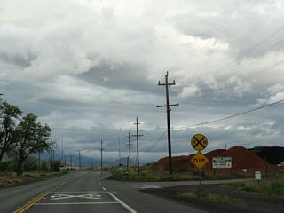 Eastbound California 3 (Montague Road) passes by towering mounds of bark and other wood products offered by Shasta Forest Products Landscape Specialists.