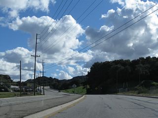 Reverting to a local road after the Newhall Avenue intersection, southbound Historic Sierra Highway (old U.S. 6) continues on a southwesterly alignment toward Newhall Pass. Between 1926 and 1930, this section of Sierra Highway was U.S. 99, but in 1930, U.S. 99 was relocated to what is now The Old Road (built as the Newhall Alternate through Weldon Canyon on what is now primarily Interstate 5). Since U.S. 6 did not extend this far southwest until 1937, the split between U.S. 6 and U.S. 99 has always been at Tunnel Station (named for a now-gone Newhall Pass Tunnel). The split at Tunnel Station is now situated at the intersection between The Old Road and Sierra Highway in the shadow of the Newhall Pass Interchange between Interstate 5 (Golden State Freeway) and California 14 (Antelope Valley Freeway). Interstate 5 (Golden State Freeway) was built through here in 1954.