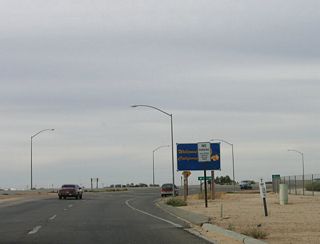 Departing from the Calexico East Border Station, this is zero postmile for California 7. A standard Welcome to California with the state flower is posted after the no parking regulatory sign.