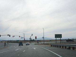 After turning right, Nina Lee Road becomes southbound California 7. The traffic signal for the Carr Road intersection comes into view as the highway passes over a drainage ditch. Soon thereafter, southbound California 7 reaches Menvielle Road (Carr Road). Turn north on Menvielle Road, then turn west on Carr Road. Carr Road travels west to serve local farms and ranches in this section of Imperial County. The construction of the port of entry, which was completed in the late 1990s, resulted in the realignment of Carr Road to the current configuration.
