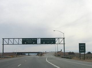 The transition of southbound California 7 onto Nina Lee Road is the "last U.S. exit." All trucks must use the left lanes to the commercial port of entry, while passenger cars must use the right lanes to transition onto Nina Lee Road. For trucks, there is no return to the United States after passing under this bridge.