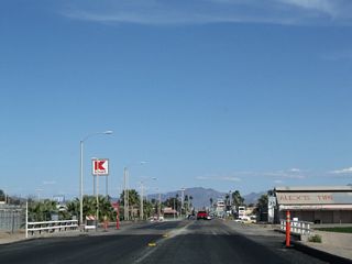 Business Loop I-10 (Hobson Way) crosses C Canal ahead of a shopping center on the north side of Hobson Way.