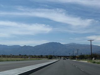 The Santa Rosa Mountains rise along the southern horizon. Traffic lights were added at the succeeding intersection with Harrison Place by 2012.