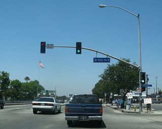 Westbound Business Loop I-10 meets Indian Hill Boulevard at this traffic signal. The city of Pomona uses a blue street sign design as compared to the green design found in Montclair.