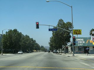 Westbound Business Loop I-10 (Holt Avenue) meets Lewis Street at this traffic signal.