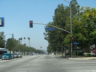 The succeeding traffic light on westbound Business Loop I-10 (Holt Avenue) is with San Antonio Avenue.
