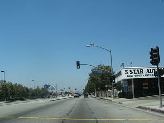 Westbound Business Loop I-10 (Holt Avenue) meets Via del Paseo at this traffic signal.