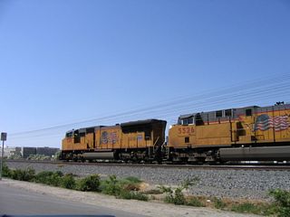 A Union Pacific locomotive comes into view alongside Indio Boulevard by Sun Gold Street.
