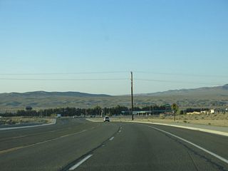 L Street expands to a five lane boulevard north from the diamond interchange (Exit 181) with Interstate 15 to Main Street. Mount General rises in the hills overlooking Barstow to the northwest.
