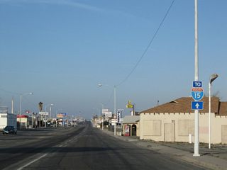 As Main Street proceeds southwest, intersecting streets increase in naming from Avenue A, Avenue B, Avenue C, etc. An I-15 trailblazer stands along Business Loop I-15 southbound by Bradshaw Drive.