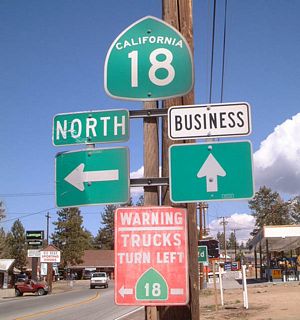 Eastbound California 18 splits with California 18 Business in the City of Big Bear Lake. This shield assembly is a variation on the bypass/business sign seen on other state routes. The mainline California 18 turns left along Paine Road to avoid the downtown area.