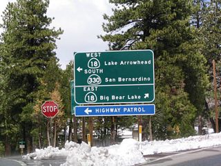 After passing through the community of Running Springs, California 18 east meets California 330 south. California 330 south follows the original route of California 30 southwest to Highland, where it ends at its junction with California 210/30. This sign is notable because it contains cardinal directions for both routes; neither California 18 nor California 330 are generally signed with cardinal direction indicators.