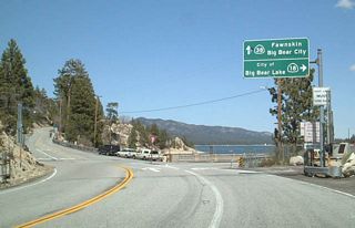 Eastbound California 18 meets California 38 at this point.  Big Bear Lake comes into view in this picture.  By following California 18 east along the south shore, motorists will cross over the dam that created this lake. At the time this picture was taken, the lake was low due to drought conditions that have remained for several years.